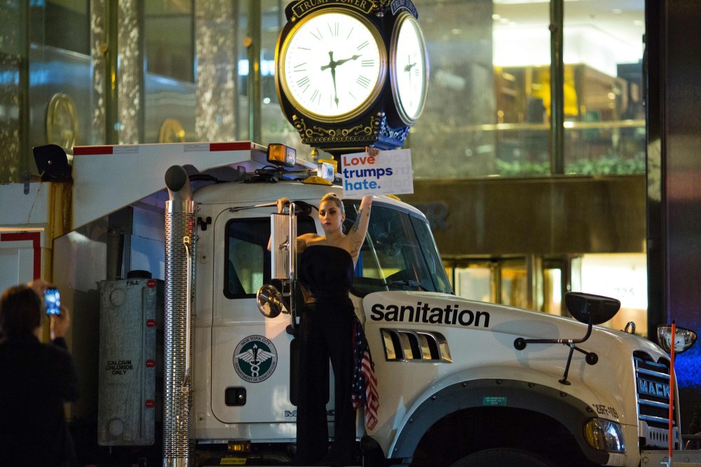 TOPSHOT - Musician Lady Gaga stages a protest against Republican presidential nominee Donald Trump on a sanitation truck outside Trump Tower in New York City after midnight on election day November 9, 2016. Donald Trump stunned America and the world, riding a wave of populist resentment to defeat Hillary Clinton in the race to become the 45th president of the United States. The Republican mogul defeated his Democratic rival, plunging global markets into turmoil and casting the long-standing global political order, which hinges on Washington's leadership, into doubt. / AFP / DOMINICK REUTER (Photo credit should read DOMINICK REUTER/AFP/Getty Images)